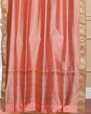 Peach sari grommet top curtains hung at a window
