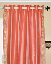 Peach sari grommet top curtains hung at a window