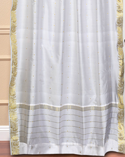 White sari grommet top curtains hung at a window