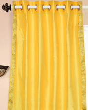 Yellow sari grommet top curtains hung at a window