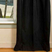 Black velvet grommet top curtains hung at a window