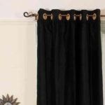 Black velvet grommet top curtains hung at a window