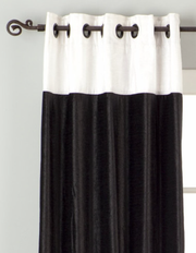 Black velvet ring top curtains hung at a window