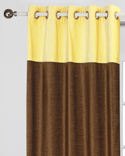 Yellow velvet ring top curtains hung at a window