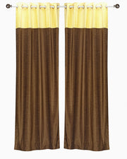 Yellow velvet ring top curtains hung at a window