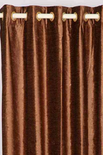 Brown velvet grommet top curtains hung at a window