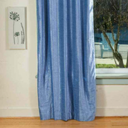 Light blue velvet grommet top curtains hung at a window