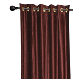 Wine velvet grommet top curtains hung at a window