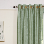 Olive green velvet grommet top curtains hung at a window