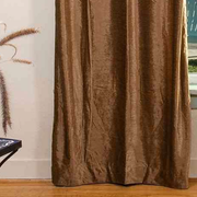 Taupe velvet grommet top curtains hung at a window