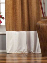 Taupe velvet ring top curtains hung at a window