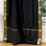 Black sari tie top curtains hung at a window