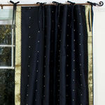 Black sari tie top curtains hung at a window