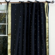 Black sari tie top curtains hung at a window