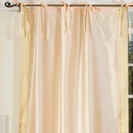 Golden sari tie top curtains hung at a window