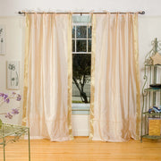 Golden sari tie top curtains hung at a window