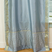 Gray sari tie top curtains hung at a window