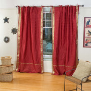 Maroon sari tie top curtains hung at a window