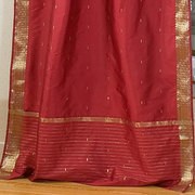 Maroon sari tie top curtains hung at a window
