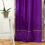 Purple sari tie top curtains hung at a window