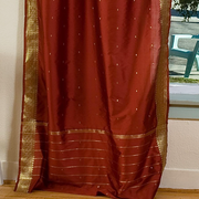 Rust sari tie top curtains hung at a window