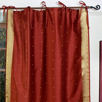 Rust sari tie top curtains hung at a window