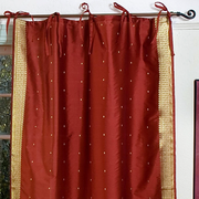 Rust sari tie top curtains hung at a window