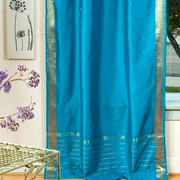Turquoise sari tie top curtains hung at a window