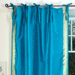 Turquoise sari tie top curtains hung at a window
