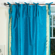Turquoise sari tie top curtains hung at a window