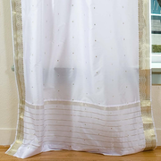 White sari tie top curtains hung at a window