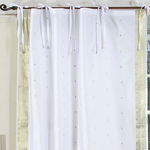 White sari tie top curtains hung at a window
