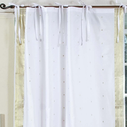 White sari tie top curtains hung at a window