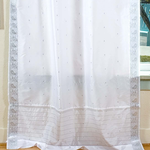 Silver sari tie top curtains hung at a window