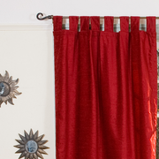 Burgundy velvet tab top curtains hung at a window