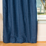 Navy blue velvet tab top curtains hung at a window
