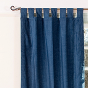 Navy blue velvet tab top curtains hung at a window