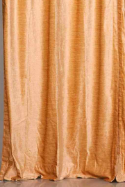 Peach velvet tab top curtains hung at a window