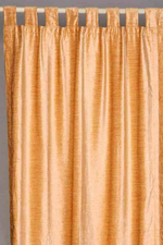 Peach velvet tab top curtains hung at a window