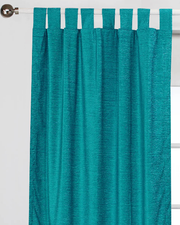 Turquoise velvet tab top curtains hung at a window