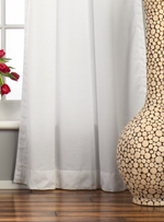 White velvet tab top curtains hung at a window