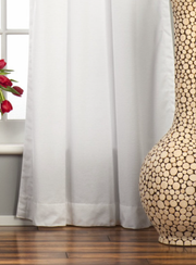 White velvet tab top curtains hung at a window