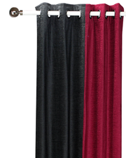 Burgundy velvet ring top curtains hung at a window