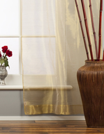 Golden rod sheer tissue rod pocket curtains hung at a window