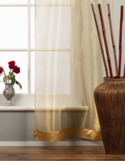 Golden rod sheer tissue rod pocket curtains hung at a window