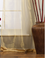 Golden sheer tissue tab top curtains hung at a window