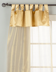Golden sheer tissue tab top curtains hung at a window