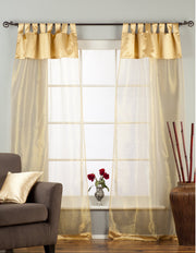 Golden sheer tissue tab top curtains hung at a window