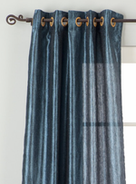Navy blue sari grommet top curtains hung at a window