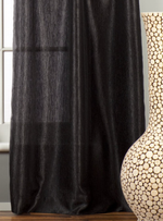 Black sari grommet top curtains hung at a window
